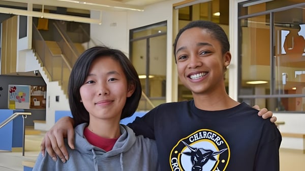 Dos mujeres están juntas en un interior del campus de la Abbey Park High School.