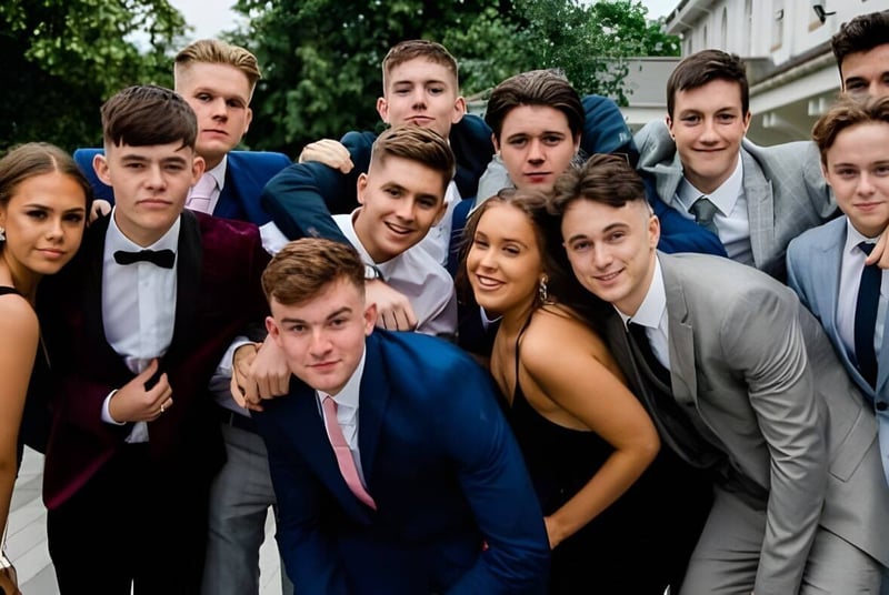 Un grupo de estudiantes de la Abbotsholme School posa afuera frente a árboles y edificios para una foto grupal.