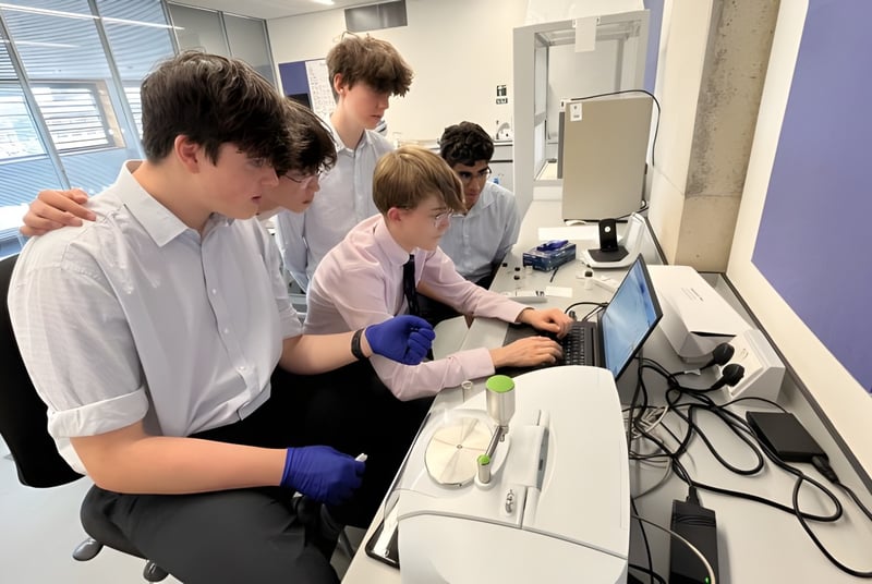 Un grupo de estudiantes de la Abingdon School trabaja en conjunto en un puesto de trabajo de computadora.