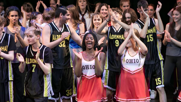 Un grupo de jóvenes celebra juntos en el terreno de la Aldenham School.
