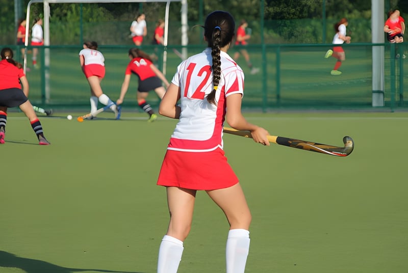 Una joven atleta sostiene un stick de hockey en el campo deportivo del Alexandra College.