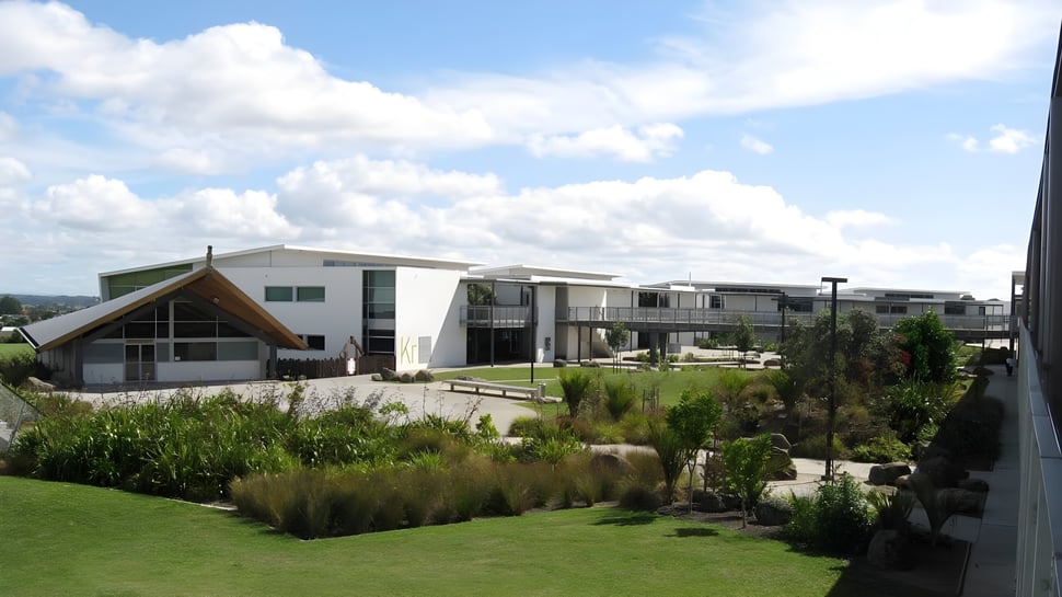 El Alfriston College muestra un moderno edificio residencial con un cuidado exterior y cielo nublado.