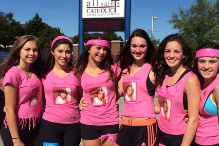 Un grupo de estudiantes está frente al edificio de la iglesia de la All Saints Catholic Secondary School.