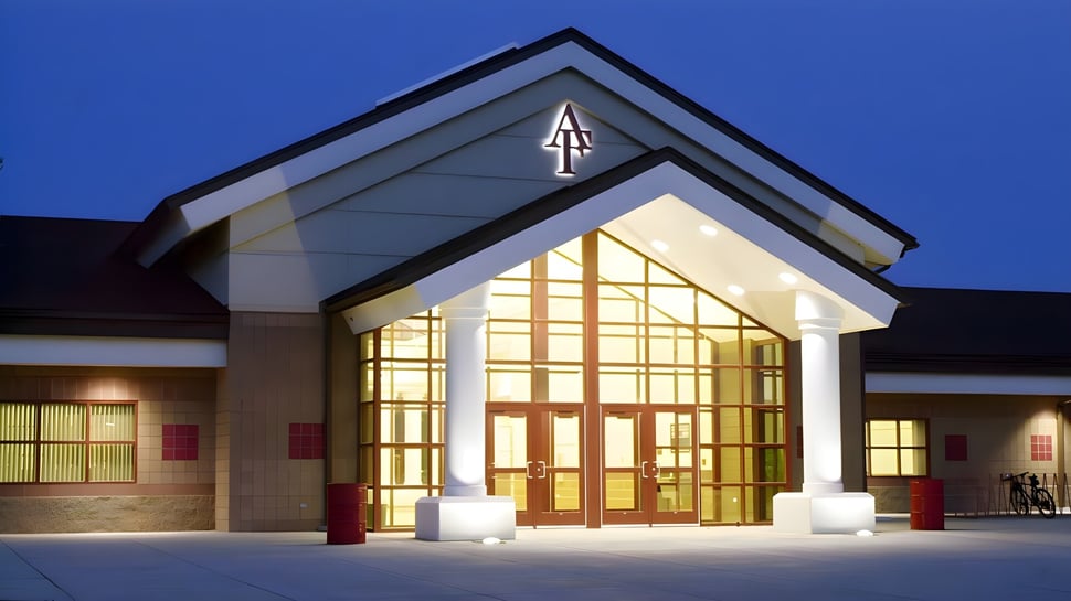 El moderno edificio de la iglesia con una gran entrada de vidrio y una cruz en la fachada en el terreno de la American Falls High School.