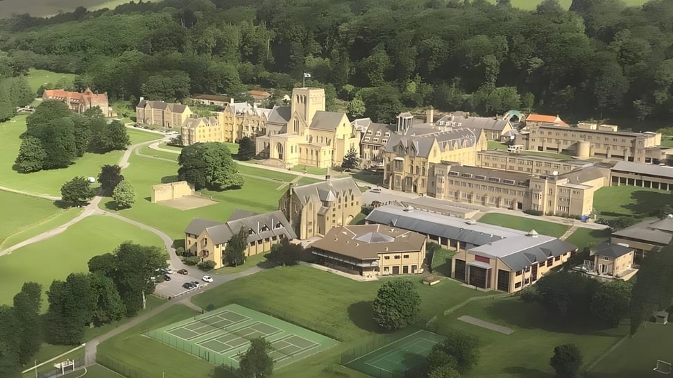 El Ampleforth College muestra un amplio castillo medieval con céspedes cuidados y canchas de tenis en primer plano.