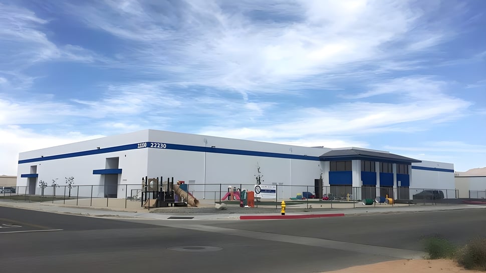 El gran edificio industrial en el terreno de la Apple Valley Christian School está rodeado de maquinaria de construcción y barreras.