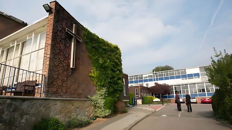 Se puede ver el edificio de ladrillo de la Archbishop's School con un jardín vertical en la fachada y un entorno moderno.