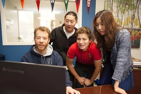 Un grupo de estudiantes de la Arroyo Pacific Academy trabaja en conjunto en una computadora.