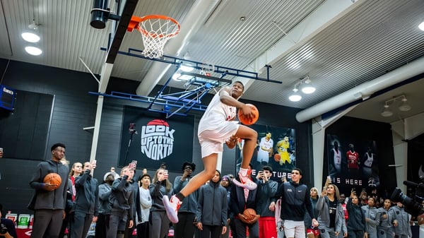 Un jugador de baloncesto salta hacia la canasta durante un evento en el Athlete Institute.