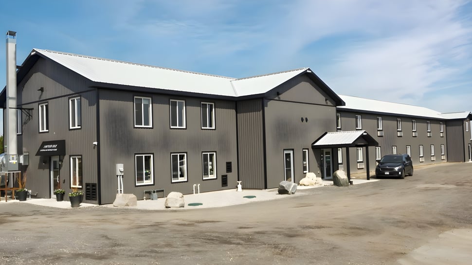 El moderno edificio de varios pisos del Athlete Institute está rodeado de un camino de grava y elementos paisajísticos.