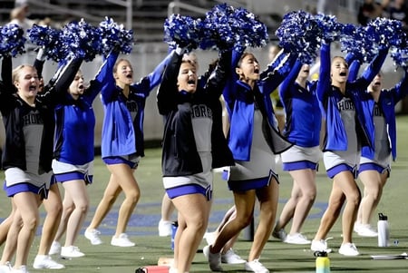 Un grupo de porristas de la Atlantic Shores Christian School realiza una coreografía en el campo deportivo frente a los espectadores.