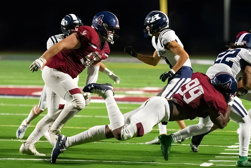 Estudiantes de la Avon Old Farms School juegan un partido de fútbol americano y realizan un placaje en el campo.