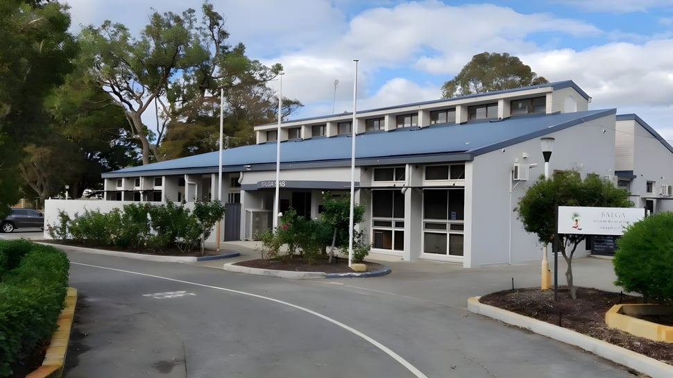 El moderno edificio principal de varios pisos de la Balga Senior High School con fachada de vidrio y áreas exteriores ajardinadas.