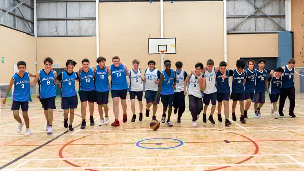 Un grupo de estudiantes juega baloncesto en el campo deportivo del Ballajura Community College.