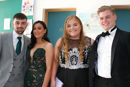 Cuatro personas en ropa formal posan juntas en un evento de la Ballinteer Community School.