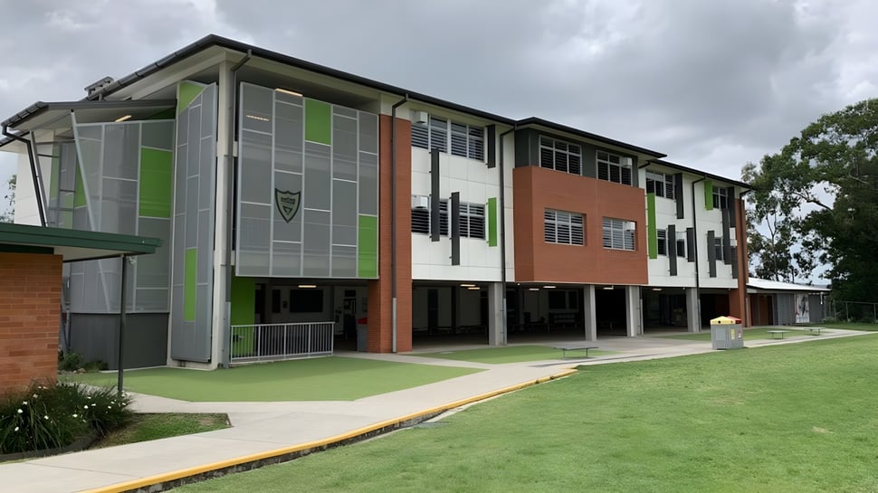 El moderno edificio de varios pisos de la Ballymahon Vocational School se encuentra en un prado verde y está rodeado de árboles.