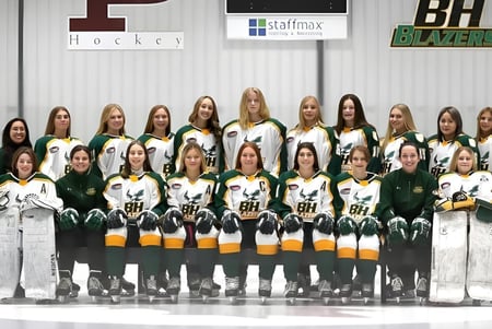 Un grupo de estudiantes de Balmoral Hall High School posan en su uniforme de hockey en una pista de hielo.