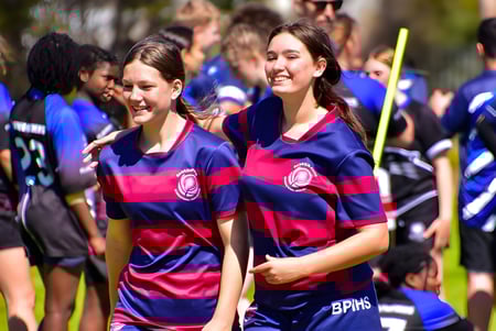 Un grupo de estudiantes de la Banksia Park International High School está junto al aire libre en uniformes deportivos a juego.