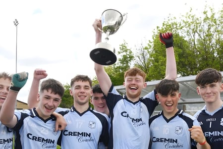 Estudiantes del Bantry Community College celebran en el campo de deportes con un trofeo en la mano.