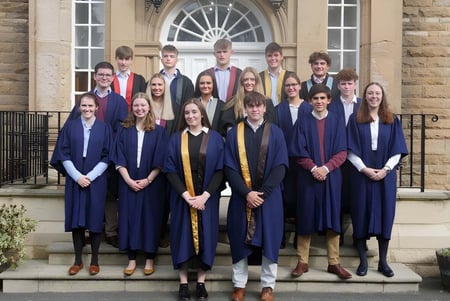 Alumnos de la Barnard Castle School están en las escaleras frente a un edificio con arquitectura ornamentada.