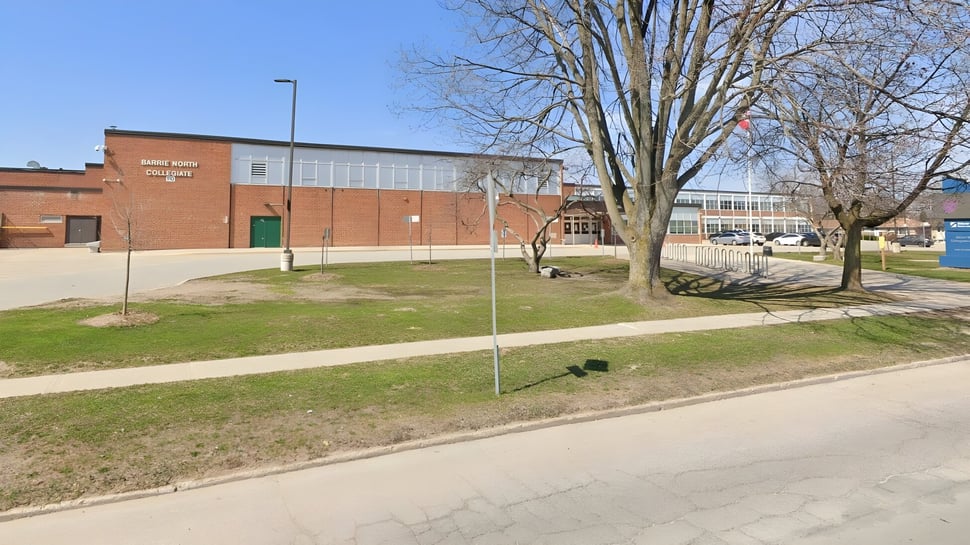 Un edificio de ladrillo con un gran cartel se encuentra en el campus del Barrie North Collegiate Institute.