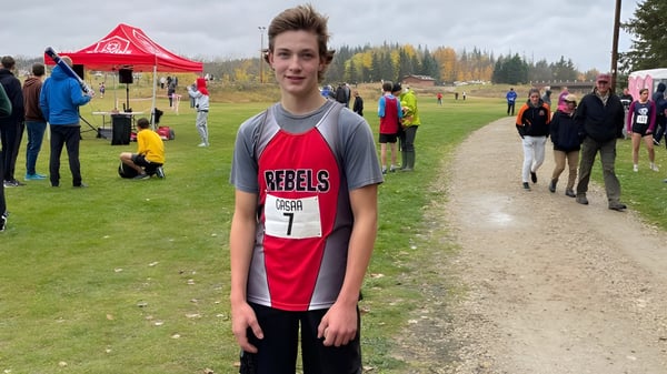 Un alumno de la Bashaw School está en un camino de campo con una tienda y otras personas al fondo.