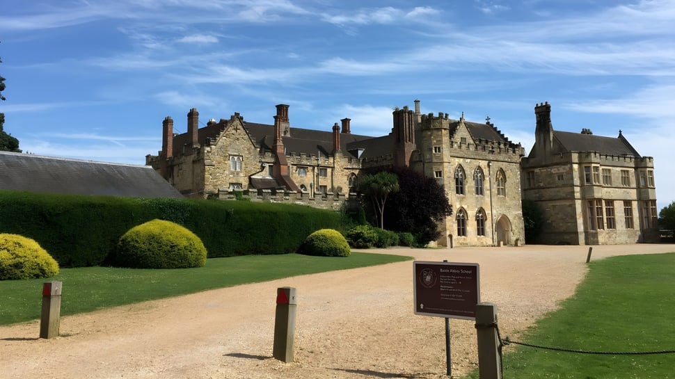 El castillo medieval de la Battle Abbey School con arquitectura elaborada se encuentra en un césped bien cuidado.