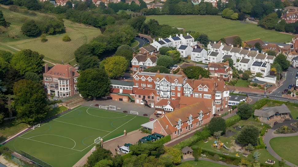 Imagen aérea del pueblo con edificios Tudor tradicionales y campo de fútbol cerca de la Bede's Senior School.