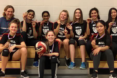 El equipo de voleibol de la Bell High School posan juntos en el gimnasio.