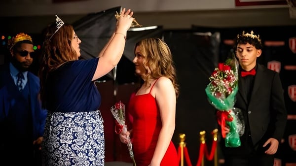 Estudiantes de la Berean Baptist Academy celebran una ocasión especial con ropa formal y los brazos en alto.