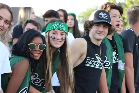 Un grupo de estudiantes de la Billings Central Catholic High School se reúne afuera y sonríe juntos.