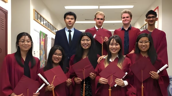 Estudiantes del Bloor Collegiate Institute están juntos en el pasillo con sus togas de graduación.