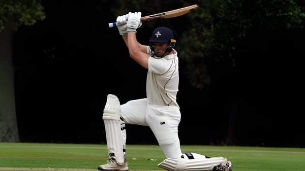 Un jugador de cricket en uniforme blanco está en el campo de la Bloxham School y se prepara para batear.