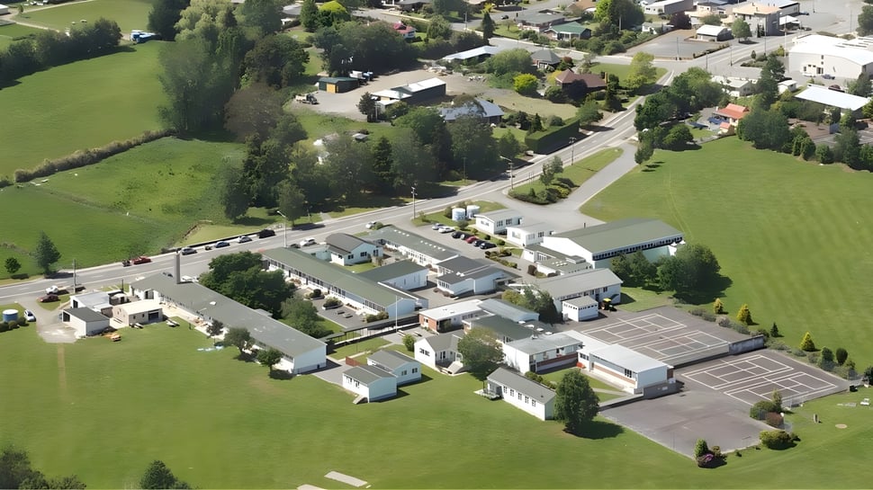 Toma aérea del entorno de Blue Mountain College con campos verdes y una red de calles.