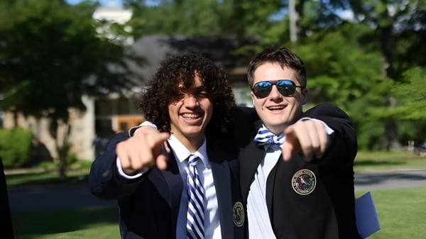 Dos estudiantes de la Blue Ridge School están al aire libre frente a árboles y sonríen a la cámara.