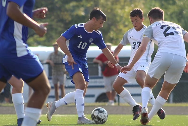 Estudiantes de la Blue Ridge School juegan un partido de fútbol en el campo de césped con varios jugadores en acción.