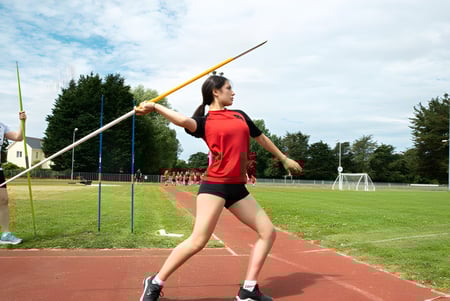 Una estudiante de Bodmin College se prepara en el campo de deportes para el lanzamiento de pértiga.