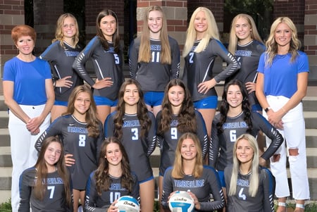 Un grupo de jóvenes atletas está en la escalera de un edificio de ladrillo en el Boise School District.