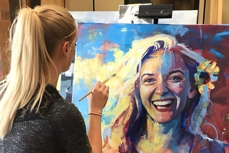 Una estudiante de la Bonneville High School pinta un retrato colorido en un lienzo en la clase de arte.