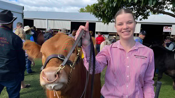 Una joven sonríe frente a un grupo de caballos en el área exterior de Bordertown High School.