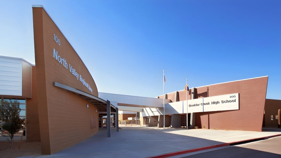 El edificio principal de la Boulder Creek High School se encuentra frente a un cielo azul claro.