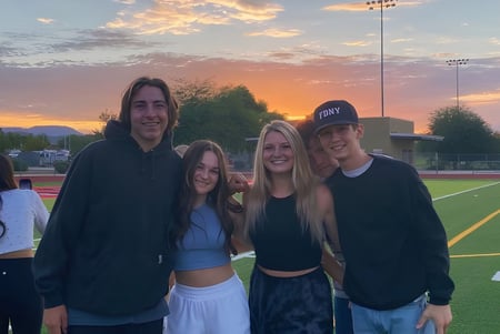 Cuatro estudiantes de la Boulder Creek High School están juntos en el campo al atardecer.