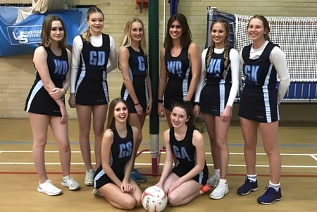 Un grupo de alumnas de Bournemouth Collegiate School posan juntas en la cancha de baloncesto.