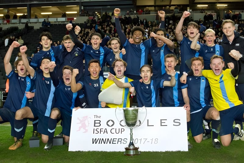 Las estudiantes del Bradfield College celebran con un trofeo en un estadio.