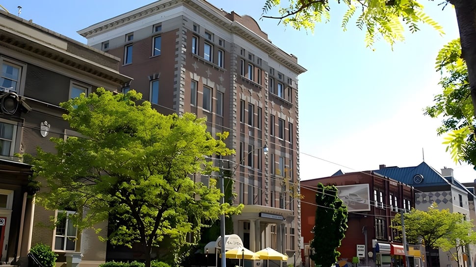 El edificio de ladrillo de varios pisos del Braemar College está rodeado de árboles verdes en un entorno urbano animado.