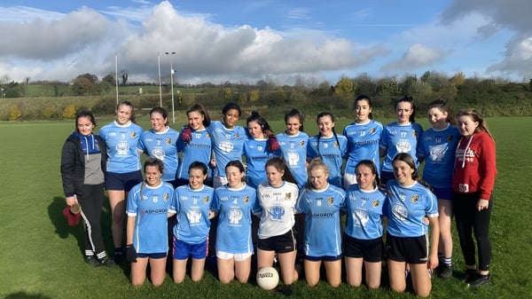 Un grupo de jóvenes futbolistas del Breifne College está de pie en un campo de hierba bajo un cielo nublado.