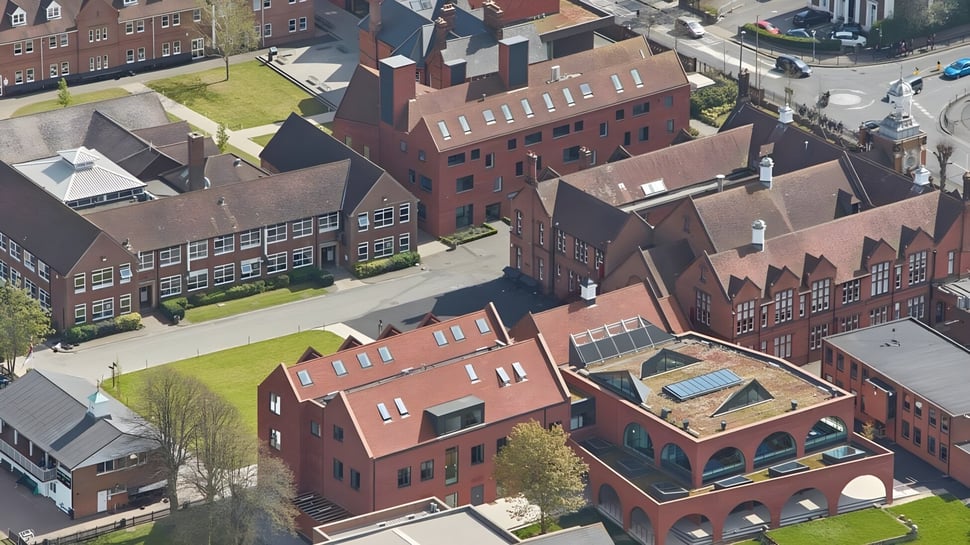 Imagen aérea del centro histórico de la ciudad con edificios de ladrillo y áreas verdes cerca de la Brentwood School.