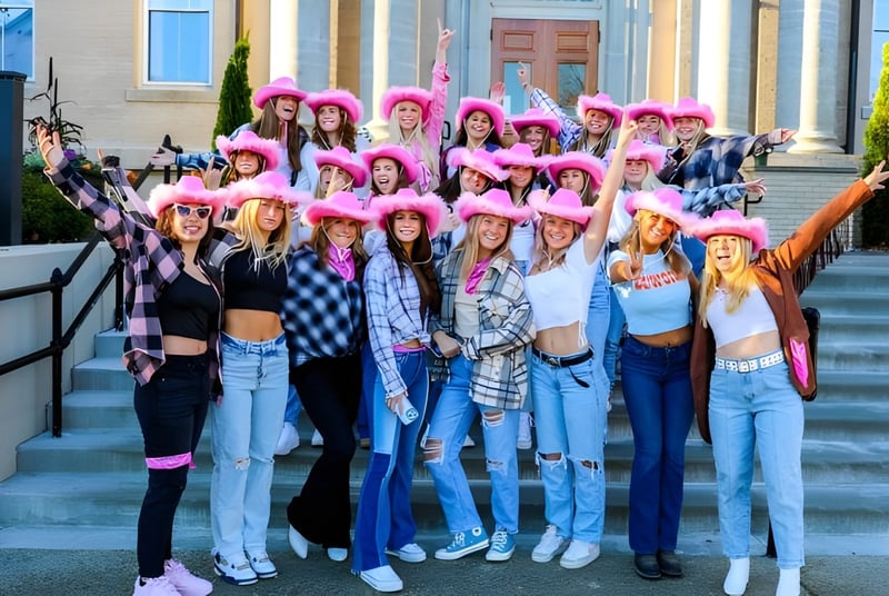 Un grupo de estudiantes de la Brewster Academy está sentado en las escaleras frente a un edificio de arquitectura clásica.