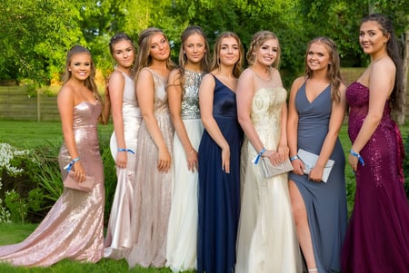 Estudiantes de la Bromsgrove School están juntas en un elegante vestido de noche en el área exterior verde.