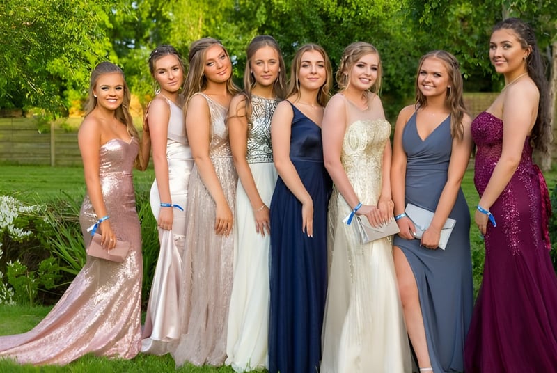 Estudiantes de la Bromsgrove School están juntas en un elegante vestido de noche en el área exterior verde.